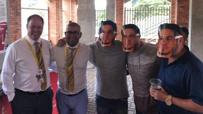 Two Cricket South Africa officials poses with fans wearing Sonny Bill Williams masks.