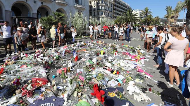 People gather near flowers placed at a makeshift memorial near the Promenade des Anglais in Nice following the Bastille Day terror attack. Picture: Valery Hache, AFP