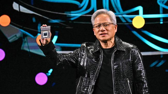 Nvidia CEO Jensen Huang holds a Nvidia's Drive Thor processor as he delivers a keynote address at the Consumer Electronics Show (CES) in Las Vegas, Nevada on January 6, 2025. Gadgets, robots and vehicles imbued with artificial intelligence will once again vie for attention at the Consumer Electronics Show, as vendors behind the scenes will seek ways to deal with tariffs threatened by US President-elect Donald Trump. The annual Consumer Electronics Show (CES) opens formally in Las Vegas on January 7, 2025, but preceding days are packed with product announcements. (Photo by Patrick T. Fallon / AFP)