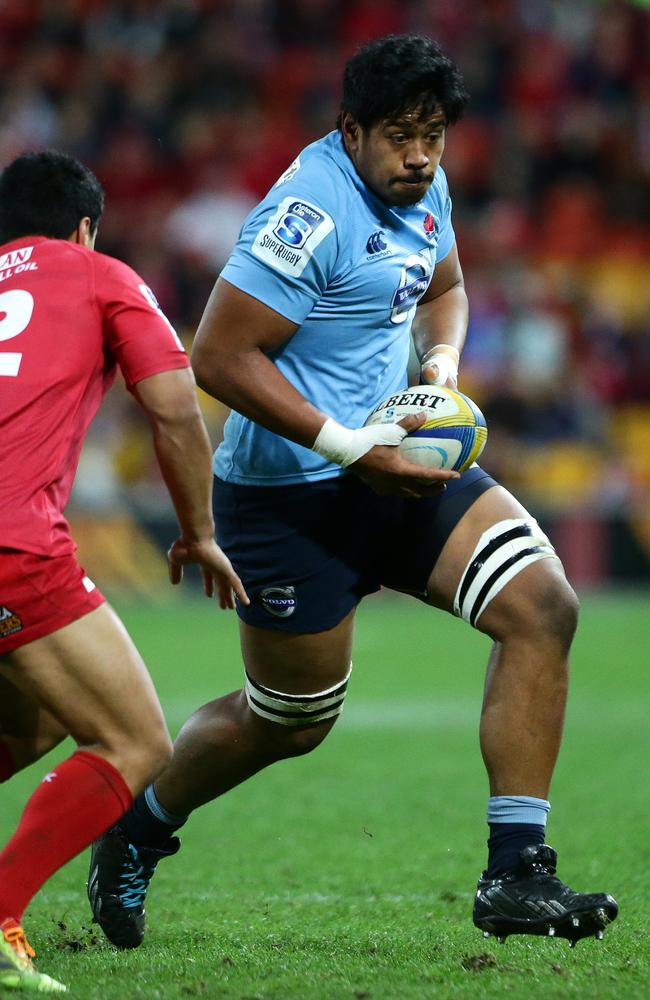 Giant Waratahs lock Will Skelton takes on the Reds defence.