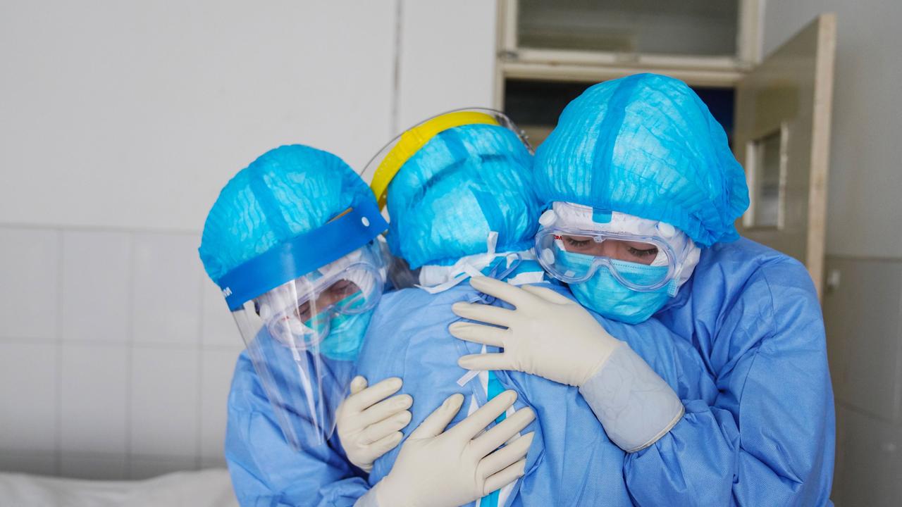 Medical staff members hugging each other in an isolation ward at a hospital in Zouping in China's easter Shandong province. Picture: STR/AFP