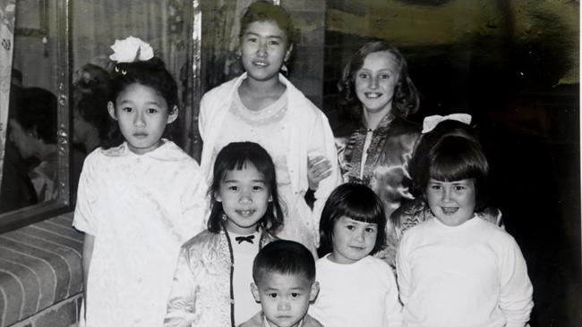 Sue-Ellen Doherty, top right, with a Chinese family in Brisbane. Her father’s role with ASIO was to “know every Chinese person in Queensland”. Picture: Supplied