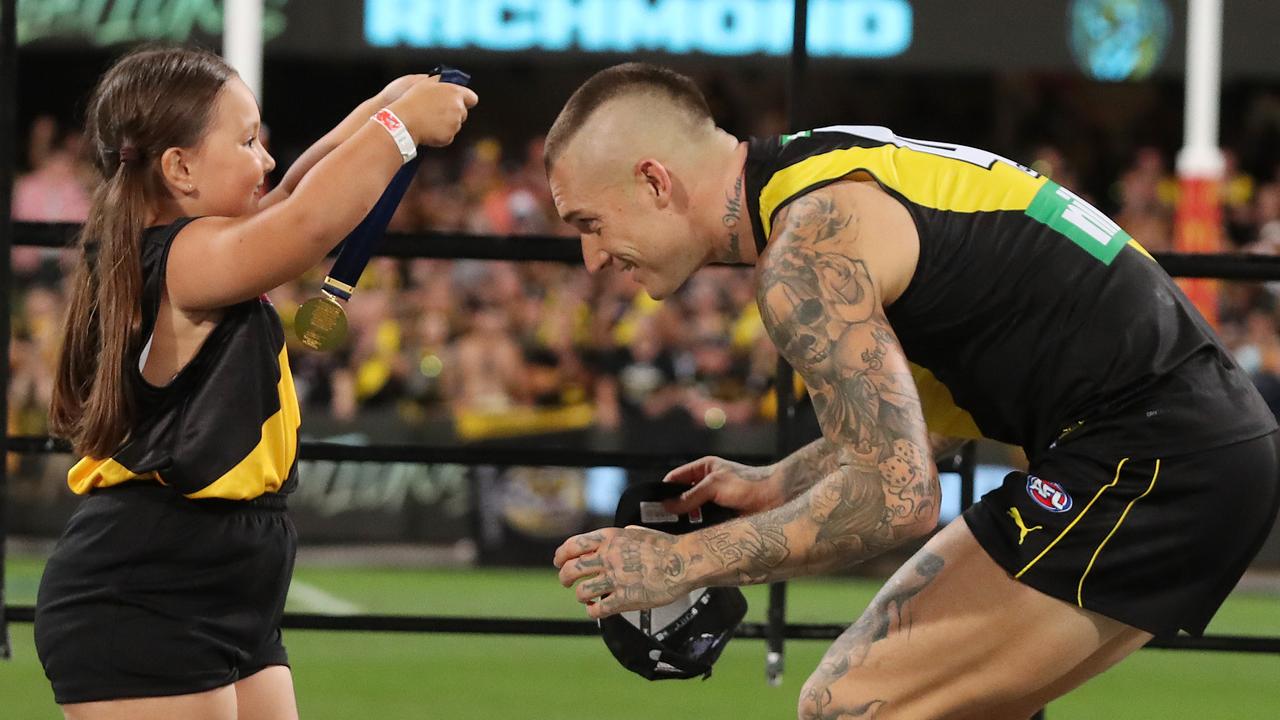 An Auskicker presents Tigers star Dustin Martin with his premiership medal after Richmond’s victory in the 2020 AFL Grand Final. Picture: Michael Klein