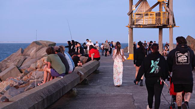 Mourners gathered at Stockton breakwall on Sunday to remember James Callahan who was stabbed and killed in Hamilton. Picture: Adam Yip