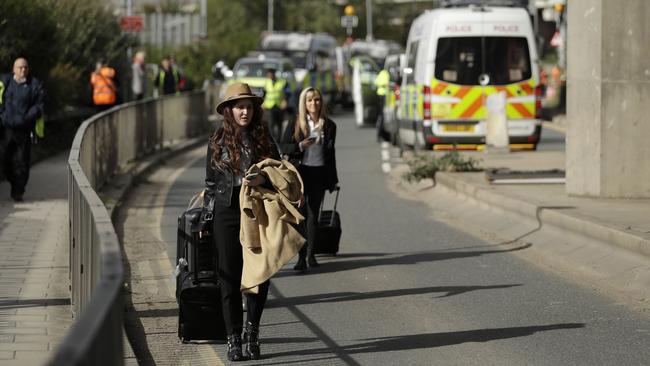 Passengers were forced to drag suitcases the last 500 metres to the airport due to the chaos caused by climate change protesters Picture: AP