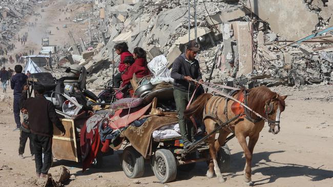 Palestinians transport belongings in Jabalia past the rubble of destroyed buildings as displaced head to the northern areas of the Gaza Strip. Picture: AFP