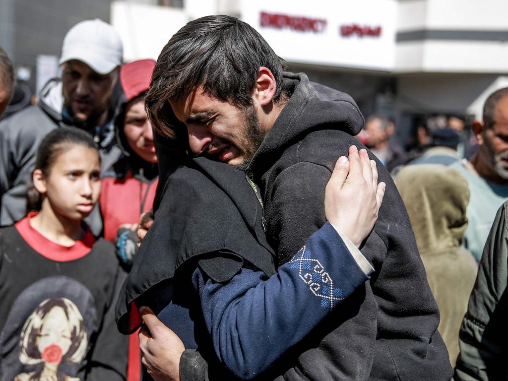 People mourn following an early morning incident when residents rushed toward aid trucks in Gaza City. Picture: AFP