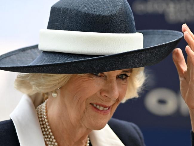 Britain's Camilla, Queen Consort holds on to her hat in the winner's enclosure on Qipco British Champions Day at Ascot Racecourse, west of London on October 15, 2022. - Champions day is the finale of the British flat racing season and the UK's richest raceday. (Photo by Glyn KIRK / AFP)