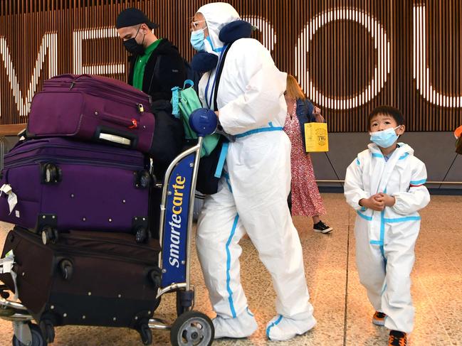 International travellers wearing personal protective equipment (PPE) arrive at Melbourne's Tullamarine Airport. Picture: William WEST / AFP