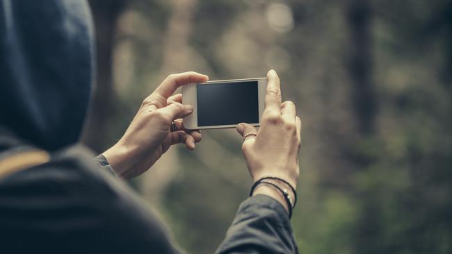 Traveler making selfie on a smart phone in the forest. Stock photo.