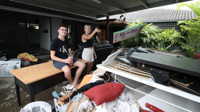 Kentia Court residents Darcy Oldaker and Summer Ryder tossing out ruined possessions. Picture: Glenn Hampson