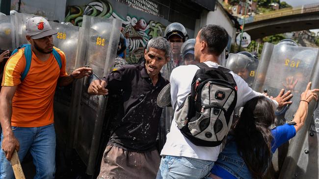 People confront riot police during a protest against the shortage of food in Caracas on December 28, 2017. Picture: AFP/Frederico Parra