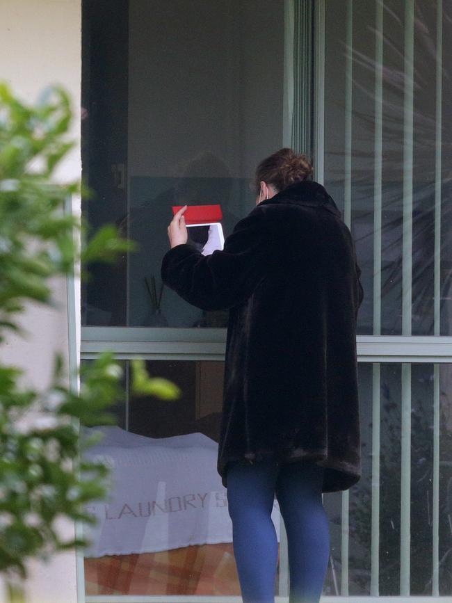 St Basil's Home for the Aged has been hit hard by COVID-19 cases. A women goes to a window at the centre to see her relative. Picture: Sarah Matray