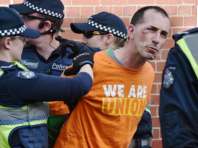 A left wing protester is restrained by police. Picture: Jake Nowakowski