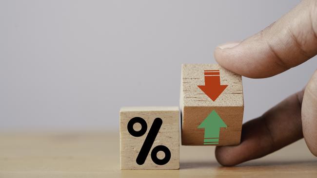 Hand flipping wooden cube block to change between up and down with percentage sign symbol for increase and decrease financial interest rate and business investment growth from dividend concept. Inflation generic