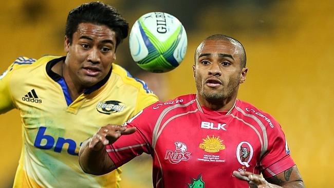 Will Genia tries to reel in a loose ball under pressure from Hurricanes winger Julian Savea.