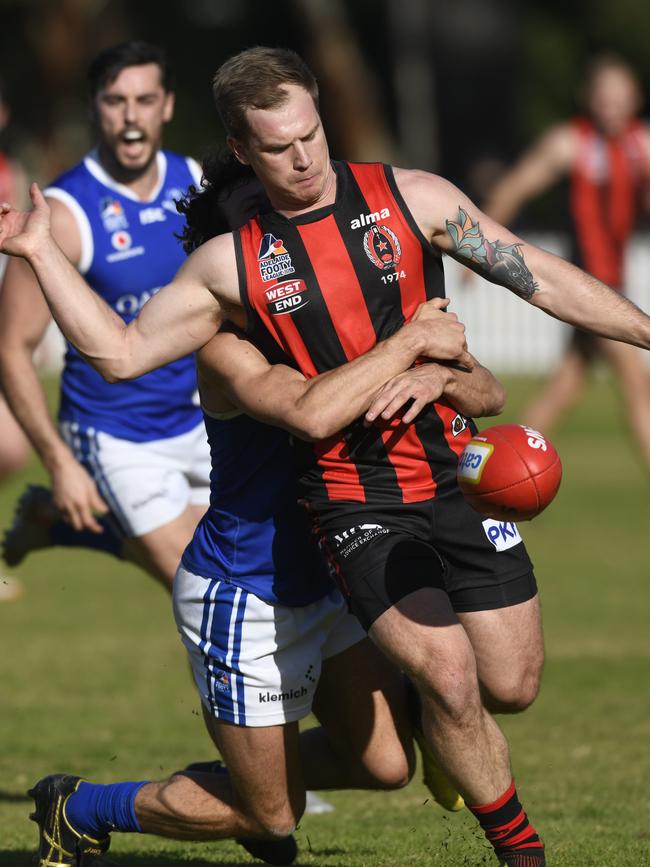 Rostrevor OC’s Dylan Reinbrecht is tackled as he takes a kick on Saturday. Picture: Naomi Jellicoe