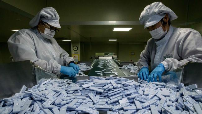 Sample testing devices used in diagnosing COVID-19 are checked on a production line Cheongju, south of Seoul. Picture: AFP