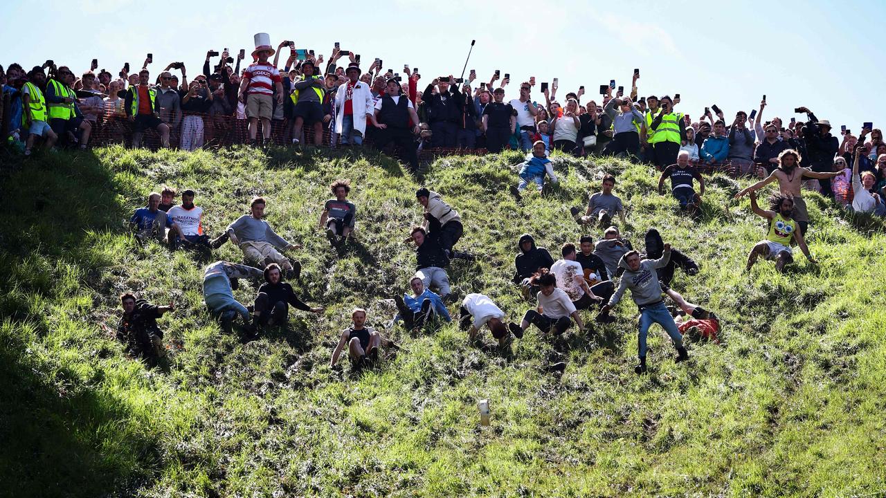 Competitors throw themselves down a hill with a 45 degree descent. Picture: Henry Nicholls/AFP