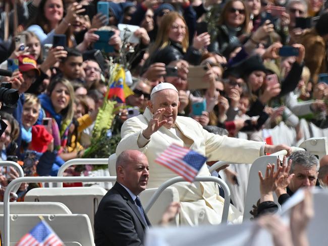 Pope Francis blesses the faithful as he tours St. Peter's square in the popemobile car following the Palm Sunday mass. Picture: AFP