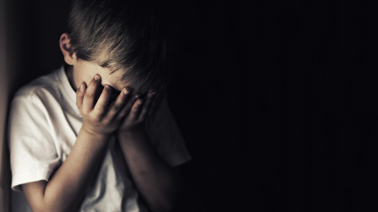 Depressed 6 years old child crying. Dark background.