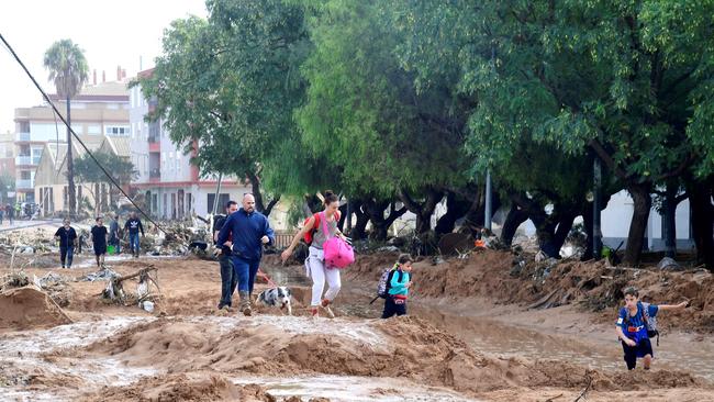 People navigated mud-covered streets in Picanya, Spain. Picture: Jose Jordan/AFP