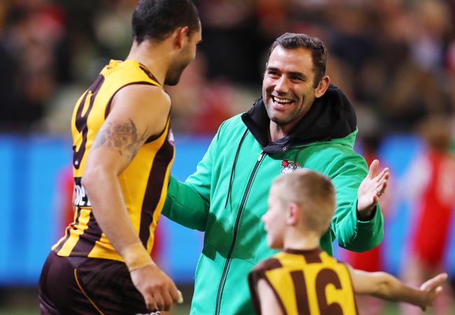 Melbourne Storm skipper Cameron Smith high fives Hawthorn's Shaun Burgoyne as he forms part of the Auskick Guard of Honour. Pic: Michael Klein