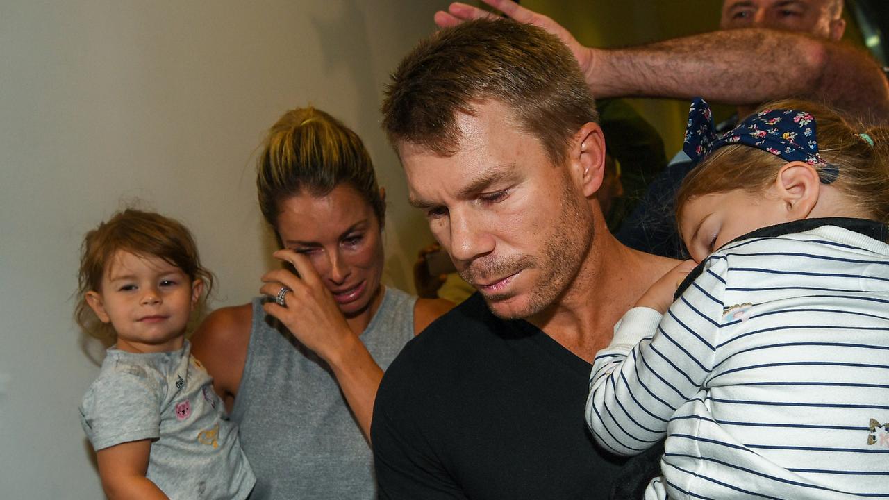 David Warner and wife Candice with their children land back in Sydney to the huge waiting media throng at Sydney airport in 2018.