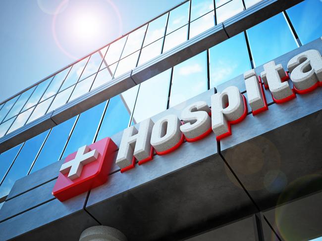 Fictitious hospital building exterior and hospital sign. Reflection of blue sky on the windows.