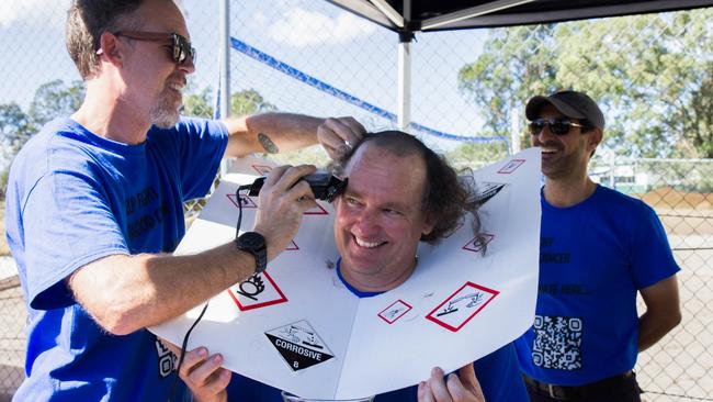 Teacher James Baulch shaves his colleague Craig Gray’s hair. Picture: Phoebe Baker