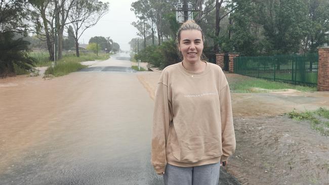 Bianca Tomelic was checking if he boyfriend can return home to Austral, but the entrance is flooded by 1pm, with more rain expected. Picture: Paul Brescia