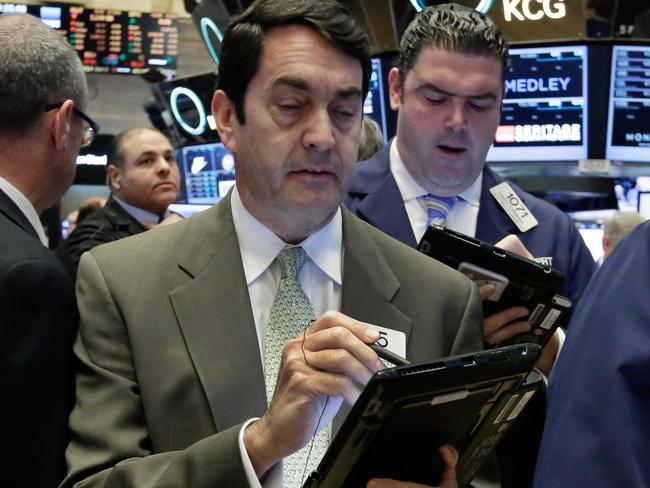 Mark Muller, foreground left, works with fellow traders on the floor of the New York Stock Exchange, Monday, Nov. 16, 2015. U.S. stocks are opening slightly higher as markets around the world are holding up better than many expected in the wake of the terrorist attacks in Paris. (AP Photo/Richard Drew)