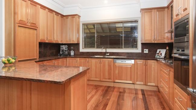 The timber kitchen has granite bench tops and top of the range appliances.