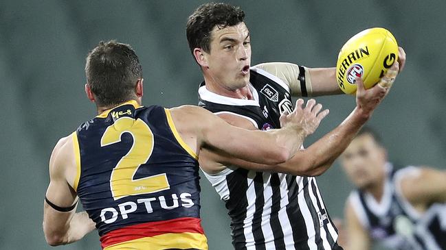 Port Adelaide’s Tom Rockliff looks to handball under close attention from Crows rival Brad Crouch during Showdown 48 at Adelaide Oval. Picture: Sarah Reed