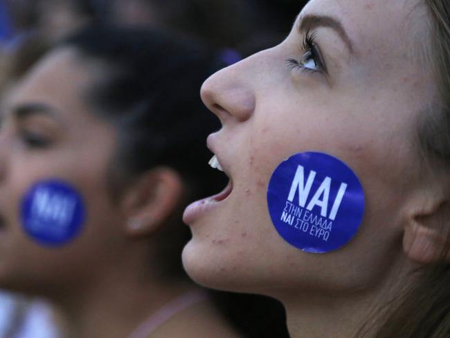 A demonstrator shouts slogans with a sticker on her cheek reading ''YES to Greece, Yes to Euro''.