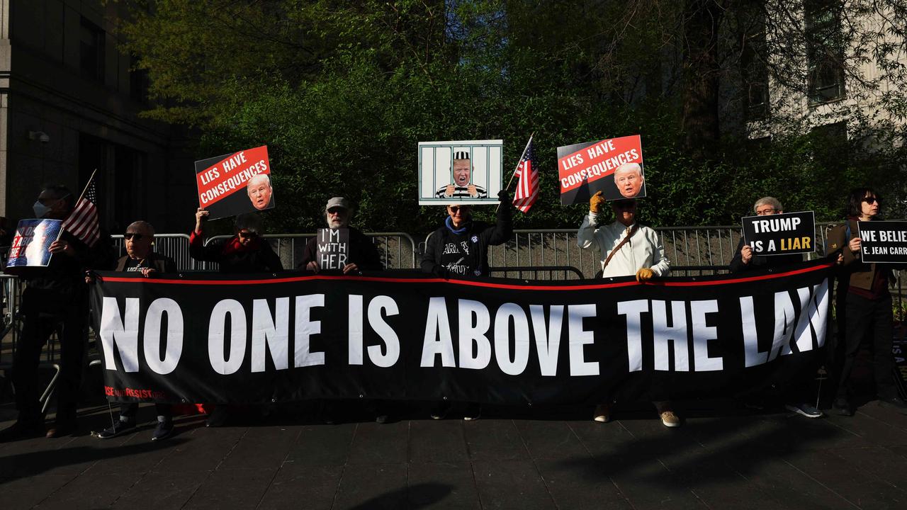 Members of Rise and Resist hold signs as they await Carroll’s arrival for the first day of her civil trial against Mr Trump at a Manhattan Federal Court. Picture: Michael M. Santiago/Getty Images via AFP