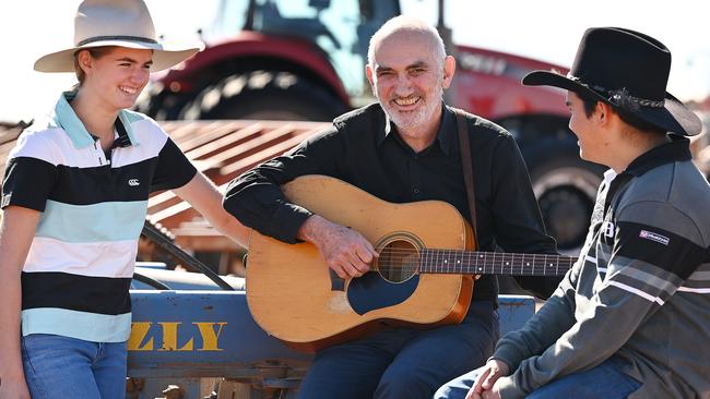 Paul Kelly with Dirranbandi State School students Julia Killen and Billy Turnbull, before his charity show in the town, 600km southwest of Brisbane, on Sunday. Picture: Lyndon Mechielsen