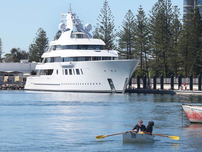 A man and his dog row to their yacht in front of Miranda Kerr and husband Evan Spiegel's  yacht, the 94.75metre Bliss, by Feadship, at Southport Yacht Club. Picture Glenn Hampson