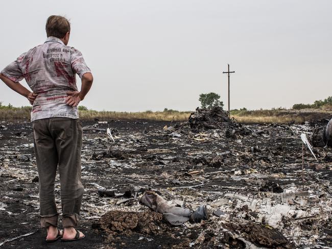 A man looks at debris from an Malaysia Airlines plane crash in Grabovka, Ukraine. Picture: Brendan Hoffman/Getty Images.