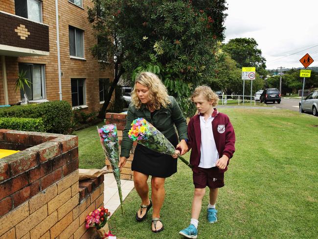 Virginia Mounfey, and Zico leave flowers at the scene where the body of an 81-year-old woman was discovered in Freshwatwer Picture: Braden Fastier