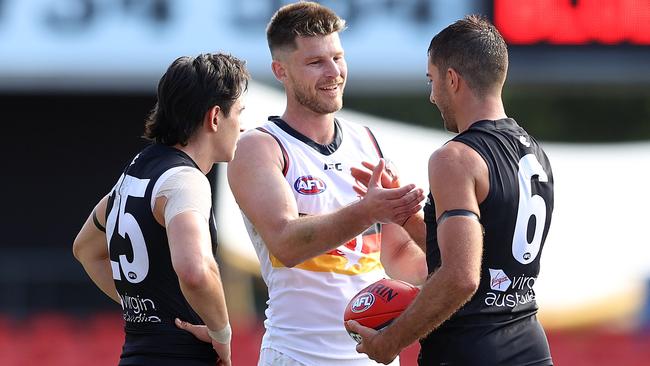 Bryce Gibbs shakes hands with Kade Simpson and Zac Fisher after his final game against Carlton at Metricon Stadium. Picture: Chris Hyde/Getty