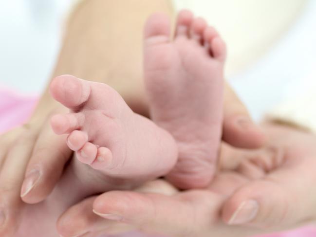 Generic photo illustrating IVF. Mother's hands holding Baby's tiny feet. Picture: iStock