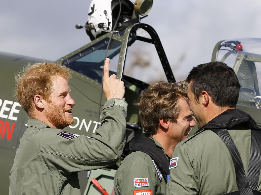 Britain’s Prince Harry jokes with pilots after a Battle of Britain display at Goodwood Aerodrome in West Sussex. Picture: AFP