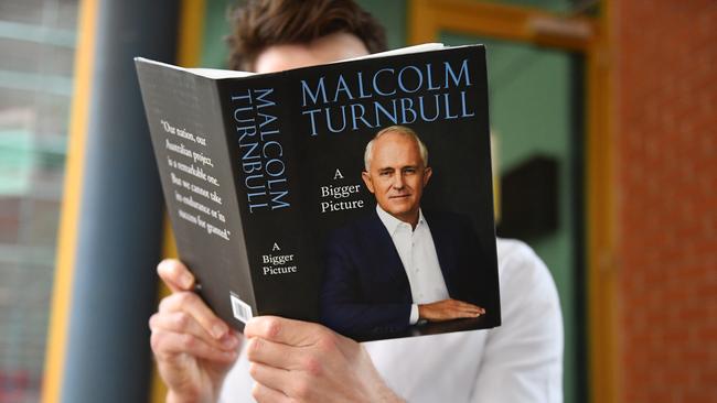 A journalist reads a copy of former prime minister Malcolm Turnbull's new book A Bigger Picture. Picture: Mick Tsikas/AAP