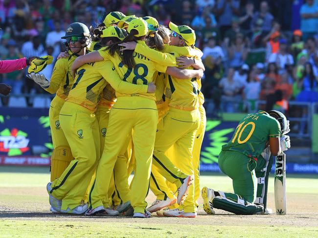 TOPSHOT - South Africa's Sinalo Jafta (R) reacts as Australian players celebrate winning the final T20 women's World Cup cricket match between South Africa and Australia at Newlands Stadium in Cape Town on February 26, 2023. (Photo by Rodger Bosch / AFP)