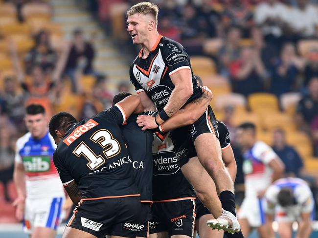 BRISBANE, AUSTRALIA - MAY 14:  Tigers players celebrate the try scored by James Tamou of the Tigers during the round 10 NRL match between the Wests Tigers and the Newcastle Knights at Suncorp Stadium on May 14, 2021, in Brisbane, Australia. (Photo by Bradley Kanaris/Getty Images)