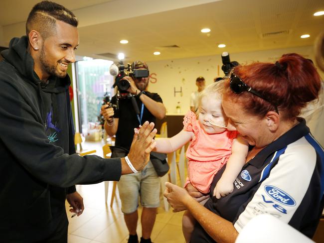 Nick Kyrgios meets Rita, 2, and mum Jodie Winderlich at Brisbane’s Ronald McDonald House on Sunday. Picture: Josh Woning/AAP