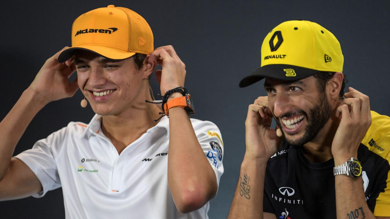 Lando Norris (L) and Daniel Ricciardo (R) react as they attend a press conference in Singapore.