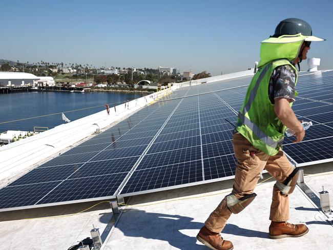 LOS ANGELES, CALIFORNIA - APRIL 21: Workers gather as they install solar panels during the completion phase of a 4-acre solar rooftop atop AltaSea's research and development facility at the Port of Los Angeles on April 21, 2023 in the San Pedro neighborhood in Los Angeles, California. The installation will supply enough energy to power AltaSeaâs 35-acre campus, the countryâs biggest 'blue economy' tech hub, which is focused on clean oceans, climate resiliency, and clean energy.   Mario Tama/Getty Images/AFP (Photo by MARIO TAMA / GETTY IMAGES NORTH AMERICA / Getty Images via AFP)