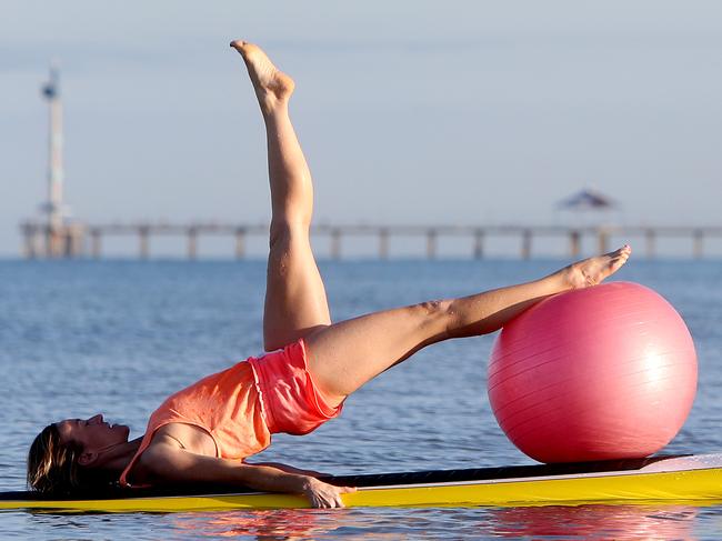 25/10/14 Simon Trangmar and Sally Danbury at Seacliff beach doing pilates on surfboards. photo Calum Robertson